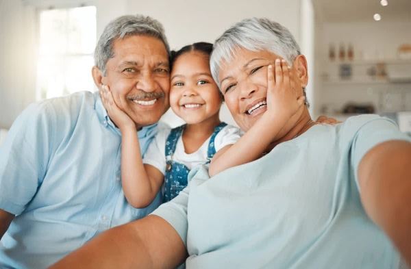 Abuelos abrazando a su nieta
